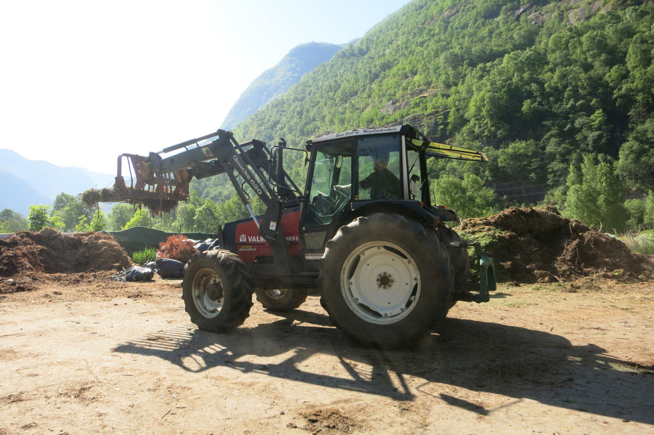 Traktor i arbeid med frontlaster under praktisk undervisning i gardsdrift.