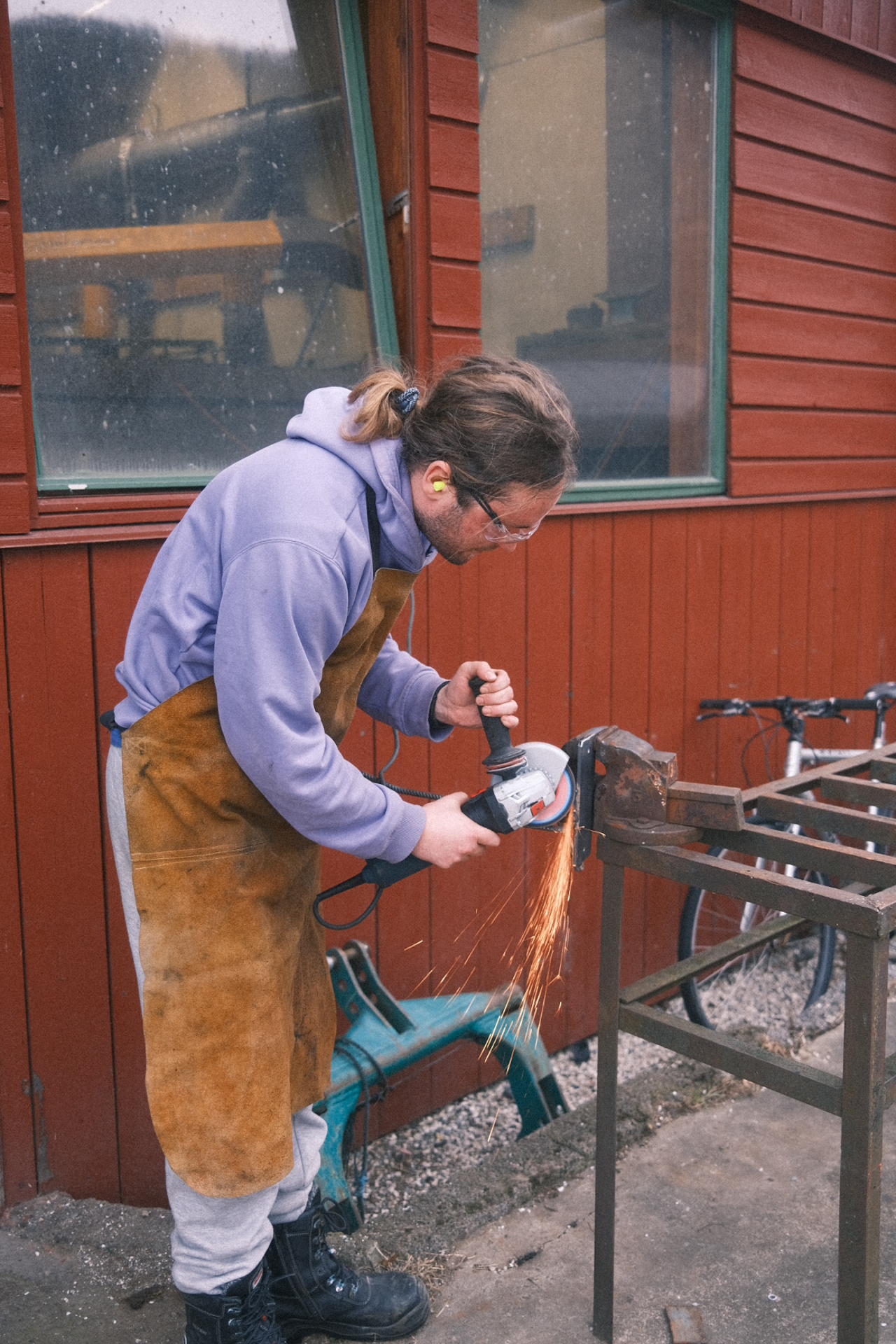 Elev i yrkesfagleg fordjuping sliper metall med vinkelslipar ved SJH.