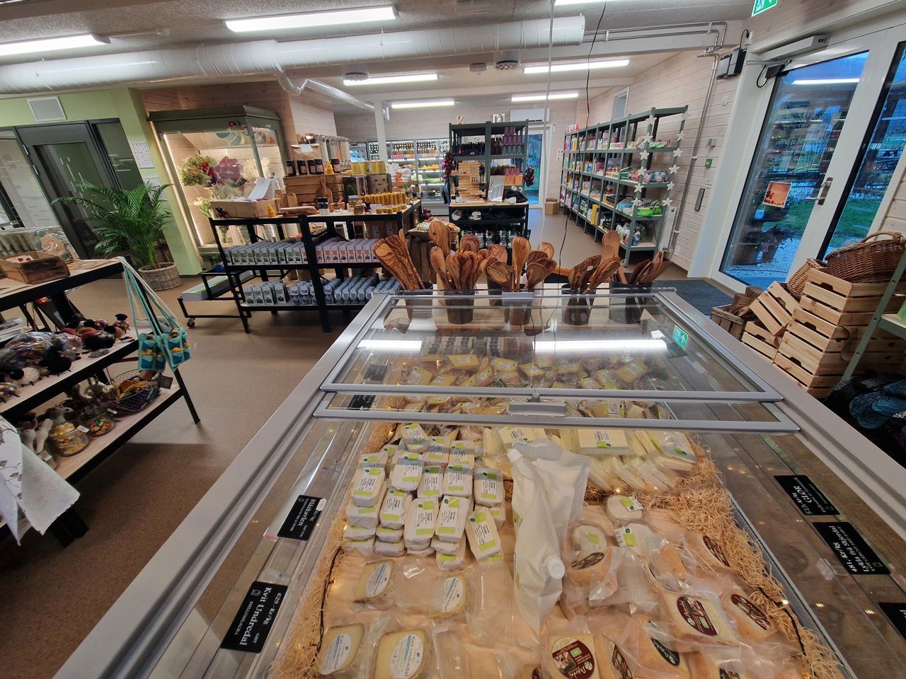 Farm shop interior with freezer display filled with organic cheese and locally produced food at SJH in Aurland.