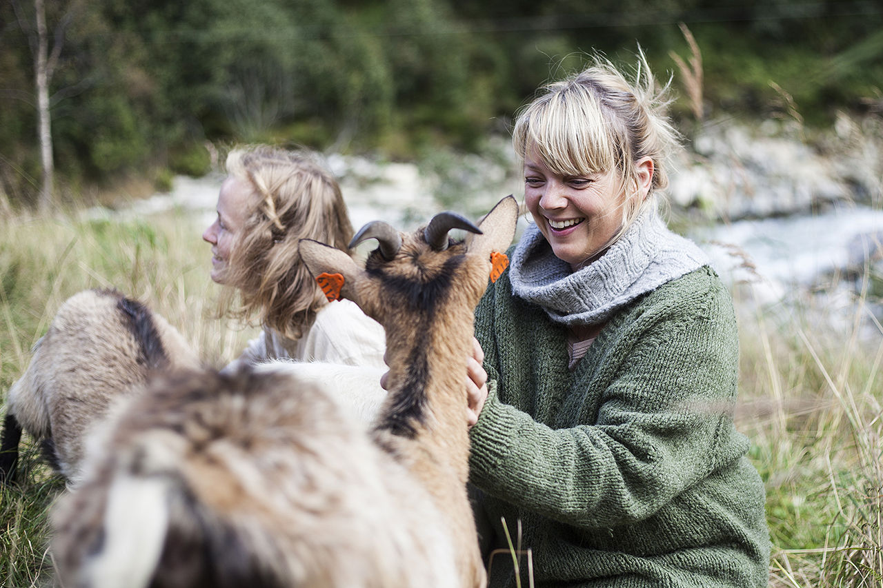 Elev kosar med geit på beite ved Sogn Jord- og Hagebruksskule i Aurland, ein del av praksisnær opplæring i økologisk landbruk.
