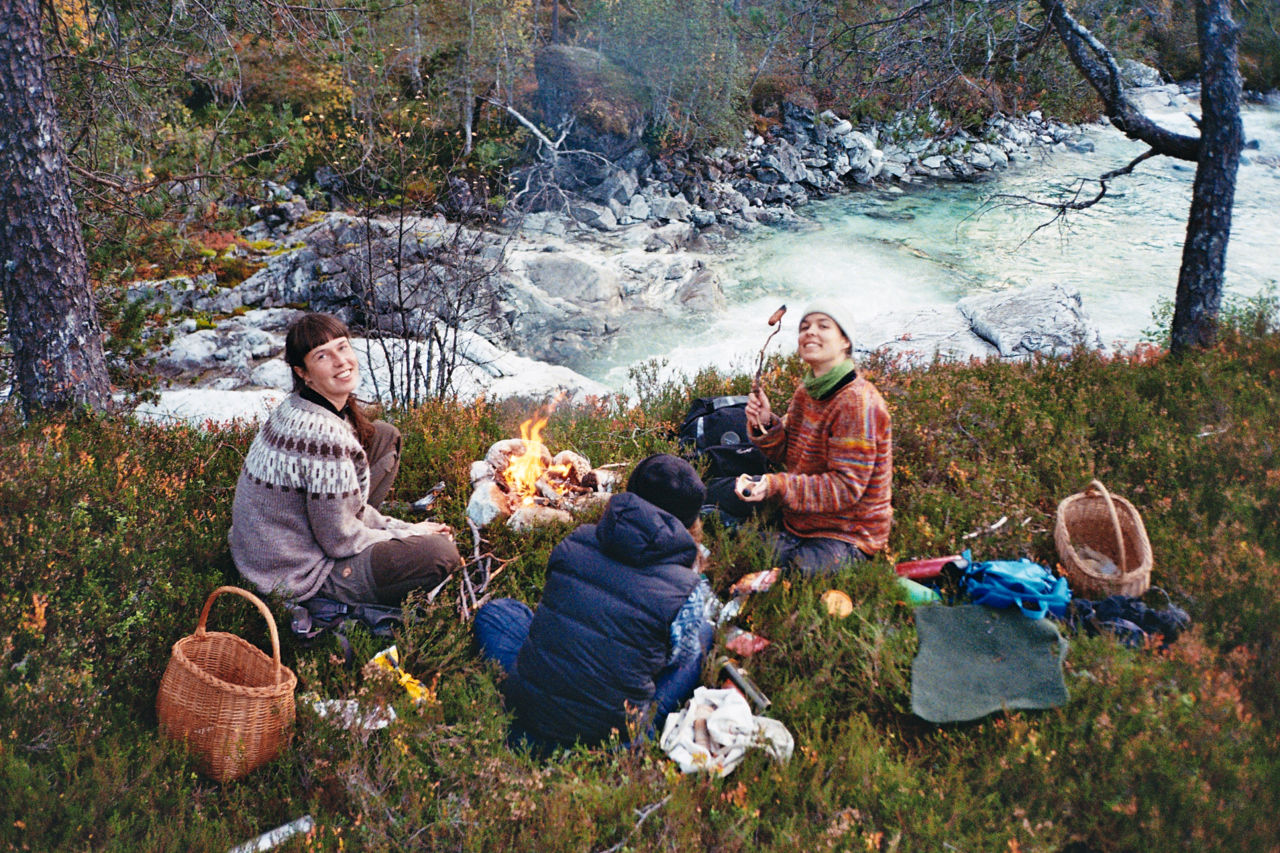 Elevar frå Sogn Jord- og Hagebruksskule på fjelltur i fritida, sittande rundt eit bål ved elvekanten.