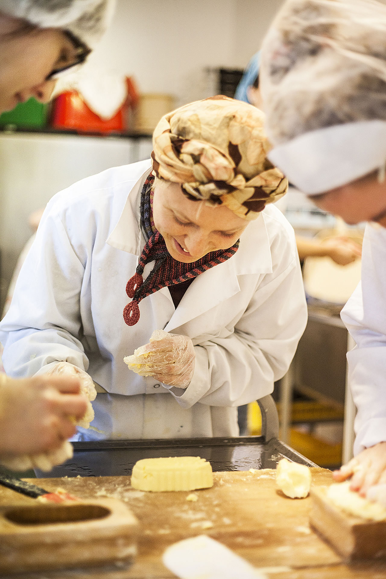 Deltakar arbeider praktisk med smørproduksjon under kurs i mjølkeforedling ved Sogn Jord- og Hagebruksskule.