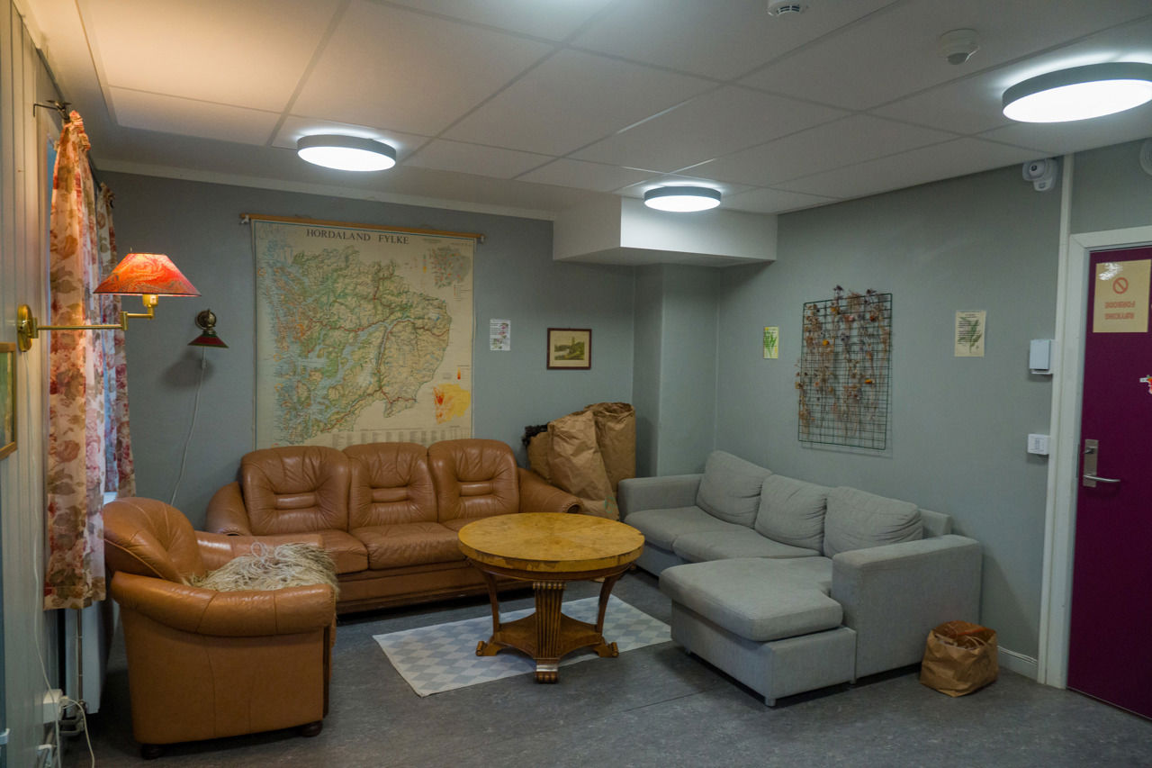 Internatet si sofagruppe med kart på veggen, lamper og sitjeplassar – eit sosialt rom for elevar ved Sogn Jord- og Hagebruksskule