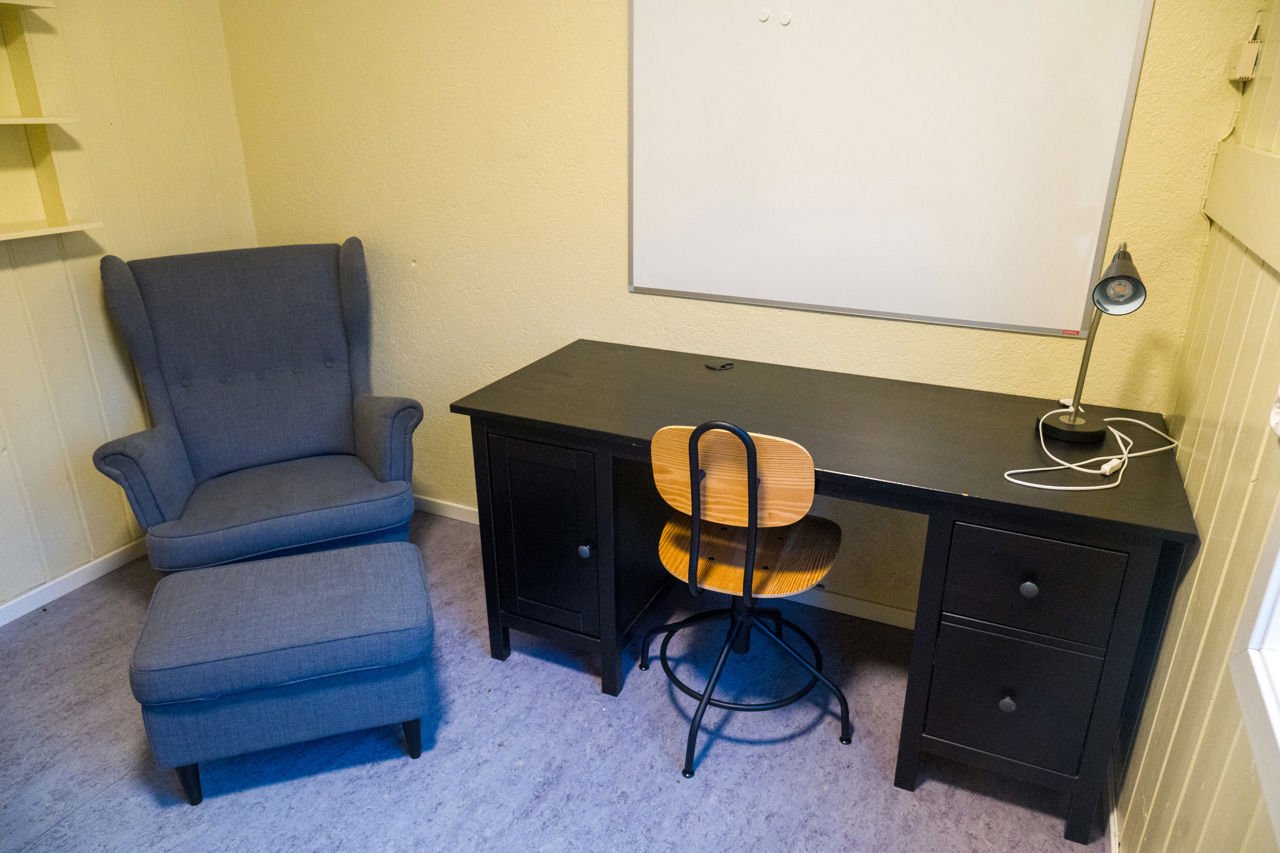 Skrivebord, arbeidsstol og lenestol på privatrommet ved internatet på Sogn Jord- og Hagebruksskule.