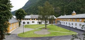 Hovedbygget ved Sogn Jord- og Hagebruksskule i Aurland omgitt av fjell og grønne omgivelser
