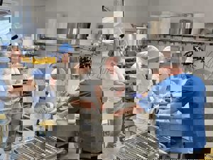 Studentar i fagskulen i handverksysting ved Sogn Jord- og Hagebruksskule får rettleiing i ysting og forming av ostemasse i skuleysteriet.