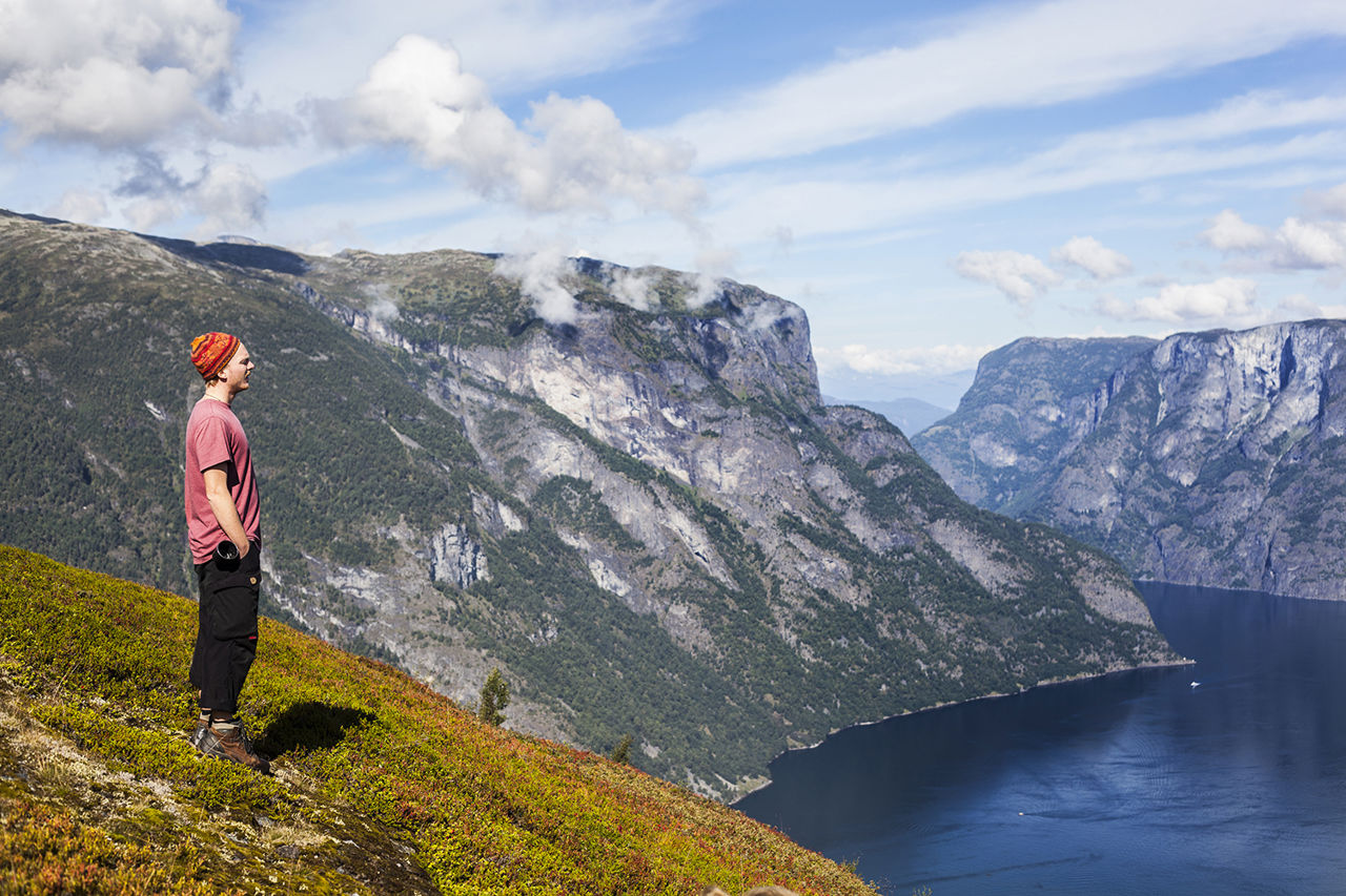 Elev står på eit fjellplatå med utsikt over Aurlandsfjorden og dei bratte fjellsidene rundt.