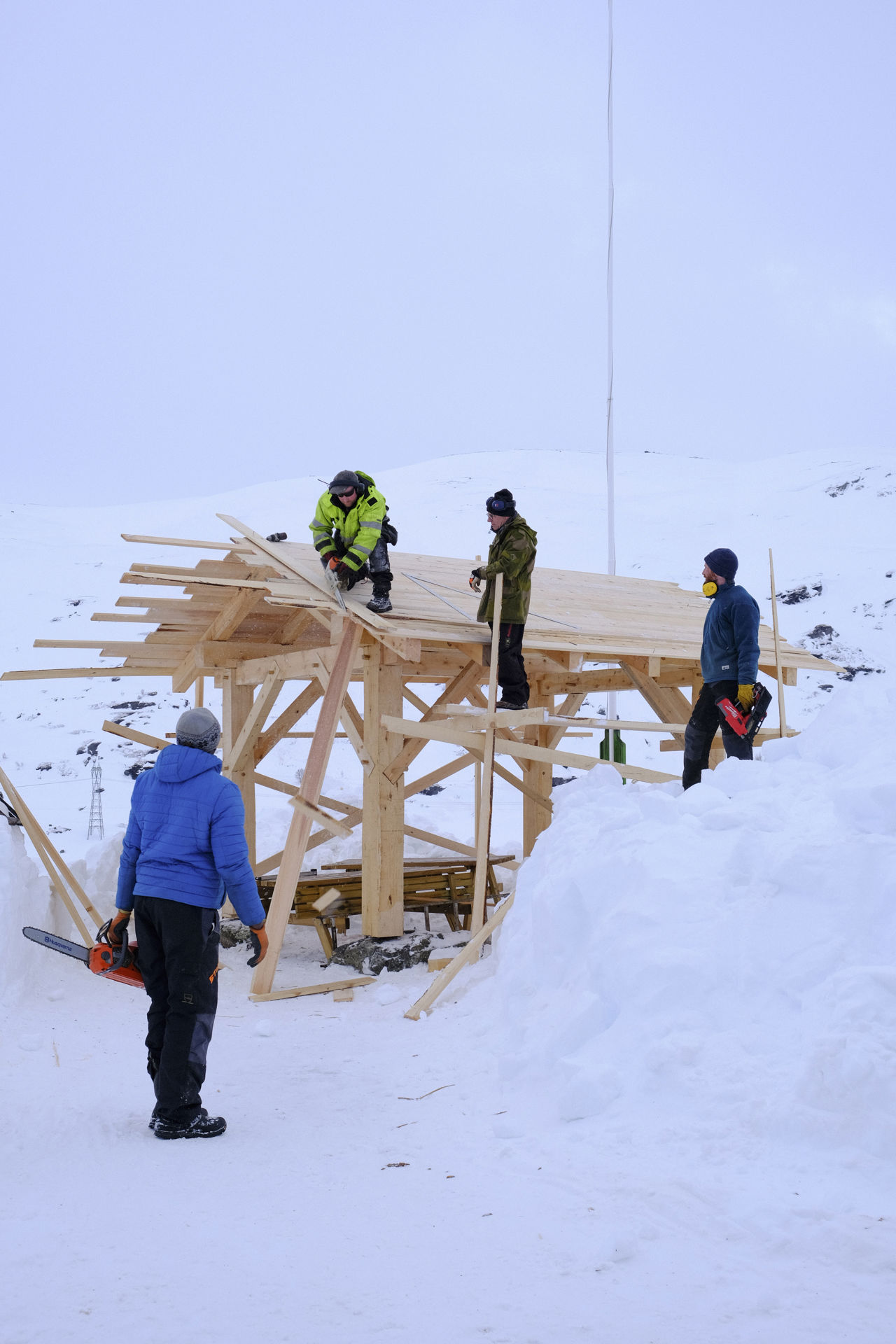 Elevar byggjer eit grindbygg ute i vinterlandskapet som del av praktisk naturbruk-undervisning.